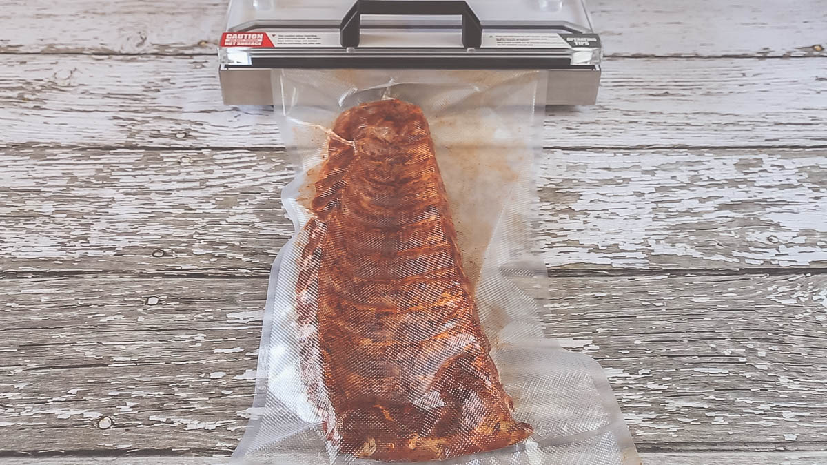 Vacuum sealed ribs marinating in a pork rub