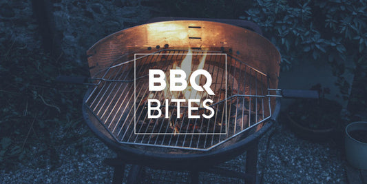 Empty charcoal grill with flames glowing at dusk, featuring 'BBQ Bites' text to introduce a grilling and vacuum sealing blog series
