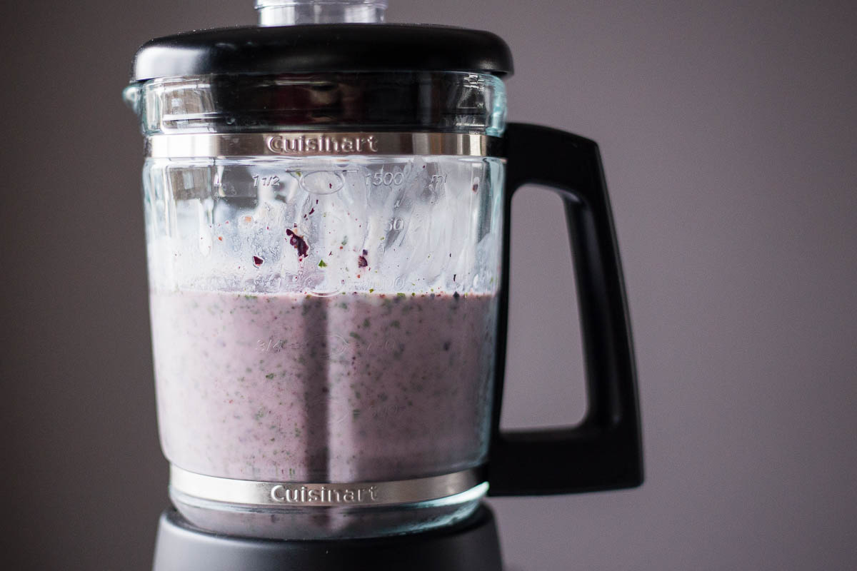Frozen kale and blueberry ingredients blended in food processor