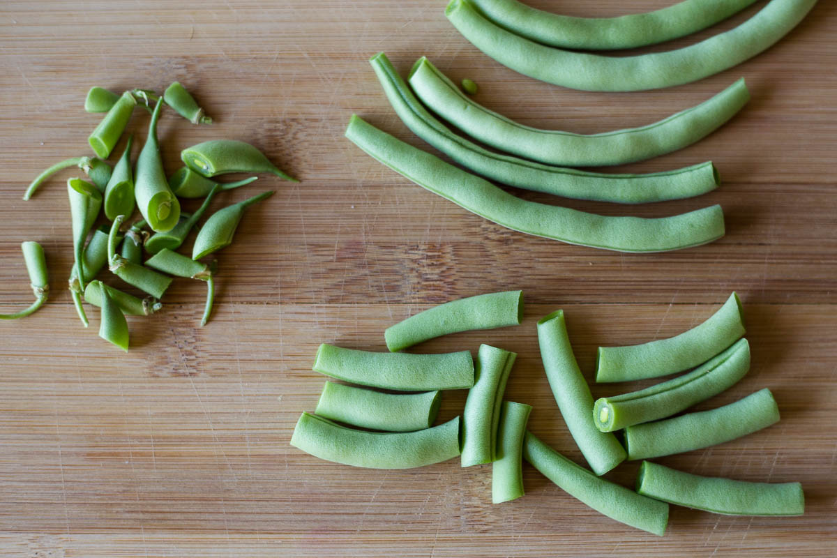 Cutting up fresh garden green beans to prepare for vacuum packaging